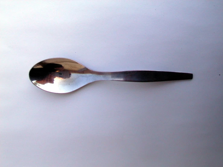 a metal spoon with a black handle sitting on top of a table