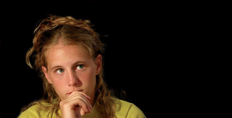 a  with long hair wearing a yellow shirt