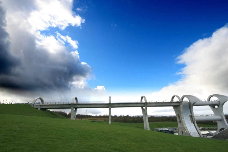 a tall bridge going over a grass covered hillside