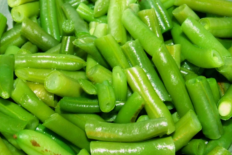 a plate full of green beans and another type of vegetable