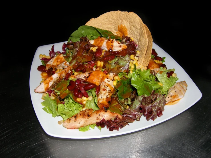 a taco and salad are on a white plate