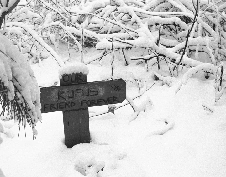 a sign on the side of a road with snow on it