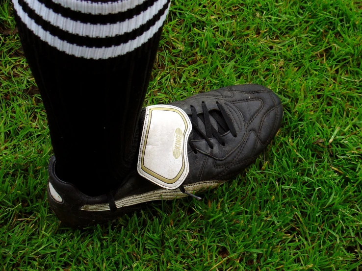 someone in black and white soccer boots in the grass