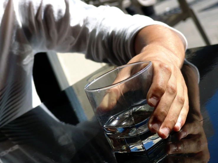 someone is holding a glass full of water