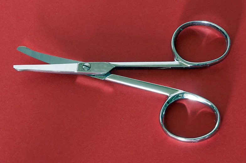 the pair of scissors is closed on a red background