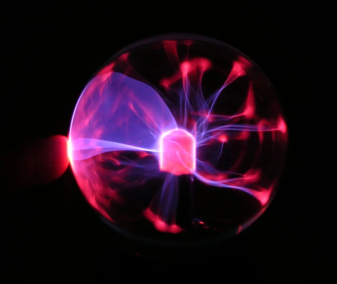 a pink object with white lights in a dark room