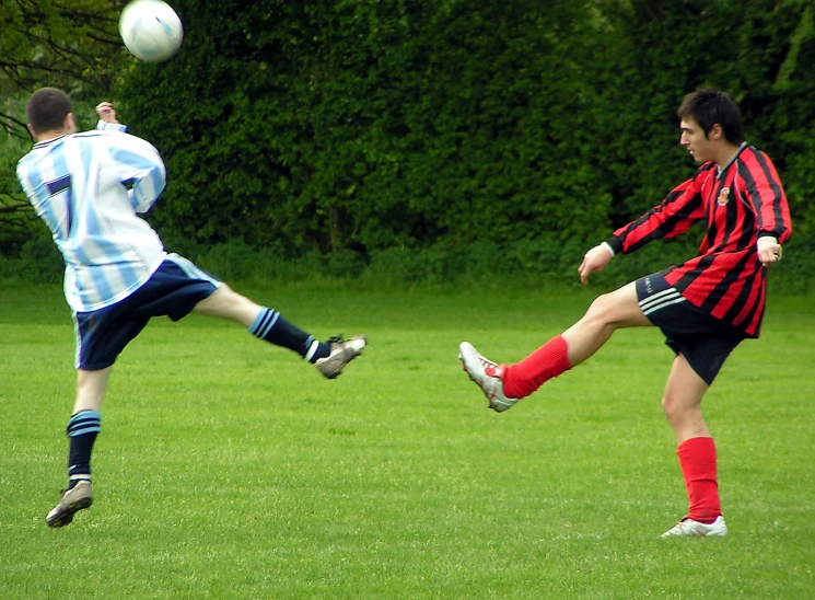 two young people on grass playing with a ball