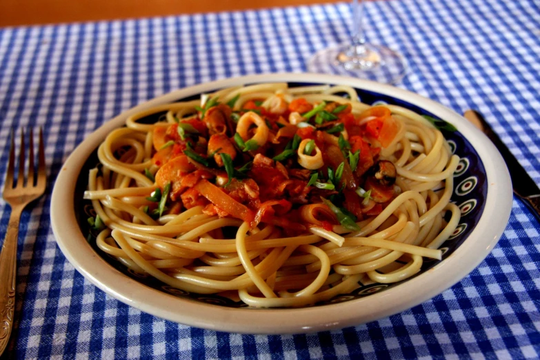 a bowl with pasta and tomatoes on the table