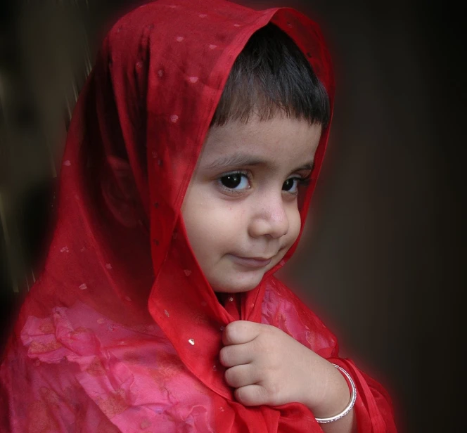 a young child dressed in a red ponched ponchee