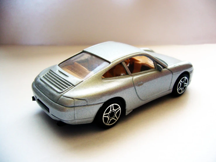 a toy ferrari on a table with a white surface