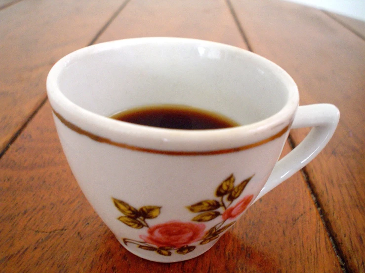 a cup filled with liquid on top of a wooden table