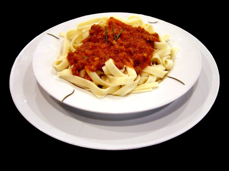 pasta with sauce and herbs on a white plate