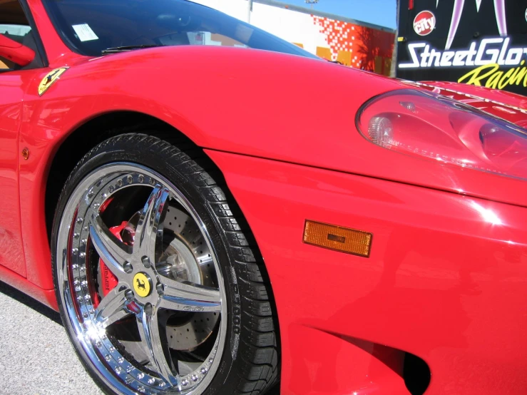 the front end of a red car with some nice wheels