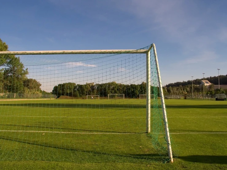 a soccer goal sits empty in an open field