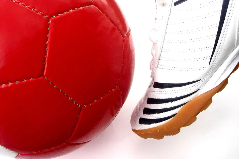 close up of soccer ball and soccer shoe on white background