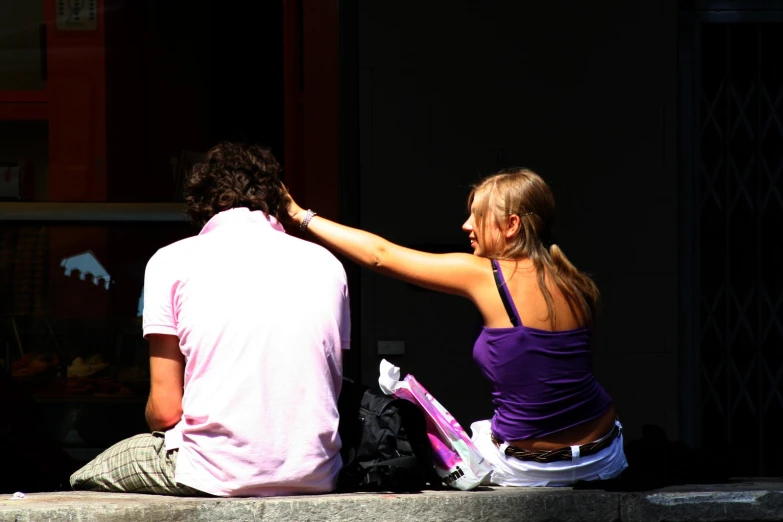 a couple is sitting down by the wall