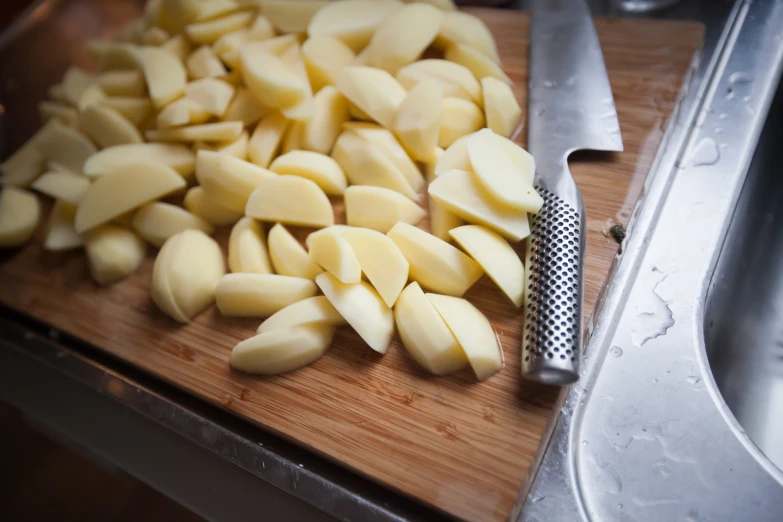 the cut up potatoes are next to the knife