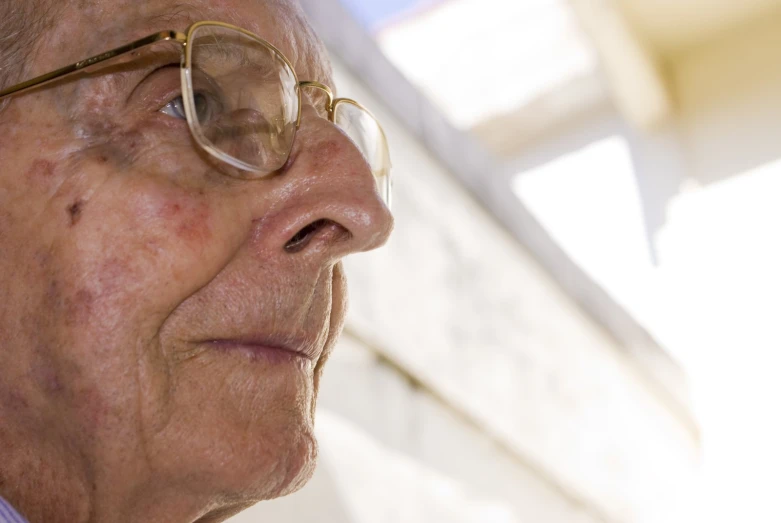 an old woman wearing eyeglasses while staring away from the camera