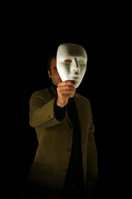 a man is holding a mask in the air