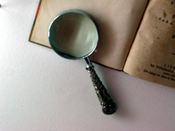 an old book is sitting next to a magnifying glass