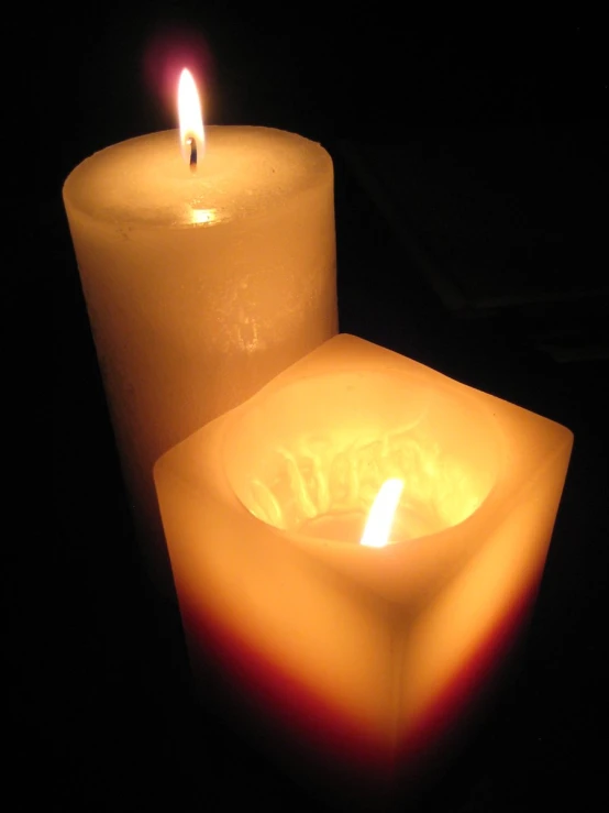 some lit candles on a black table