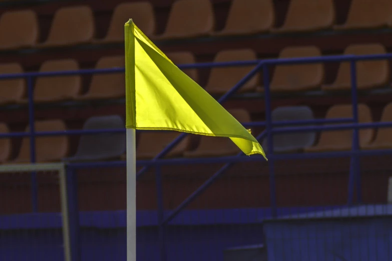 a yellow flag in the middle of an empty stadium