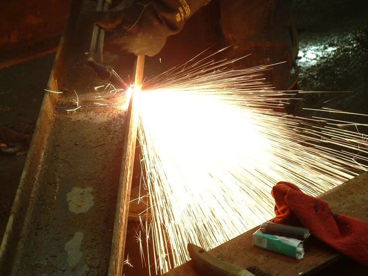 man working with sparks at metalworking shop in industrial setting