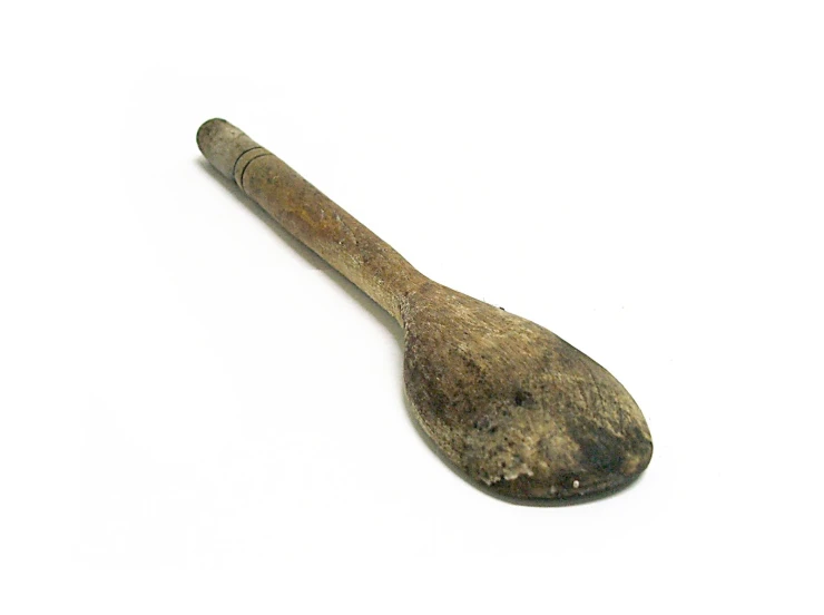 an antique wooden spoon on a white surface