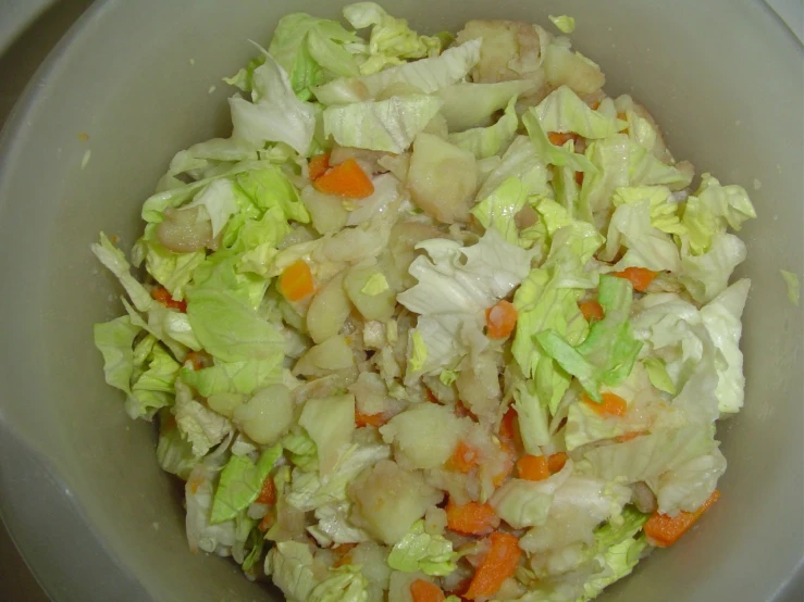 some vegetables are in a white bowl with a green surface