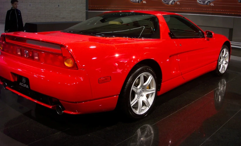 a red sports car sits in a show room