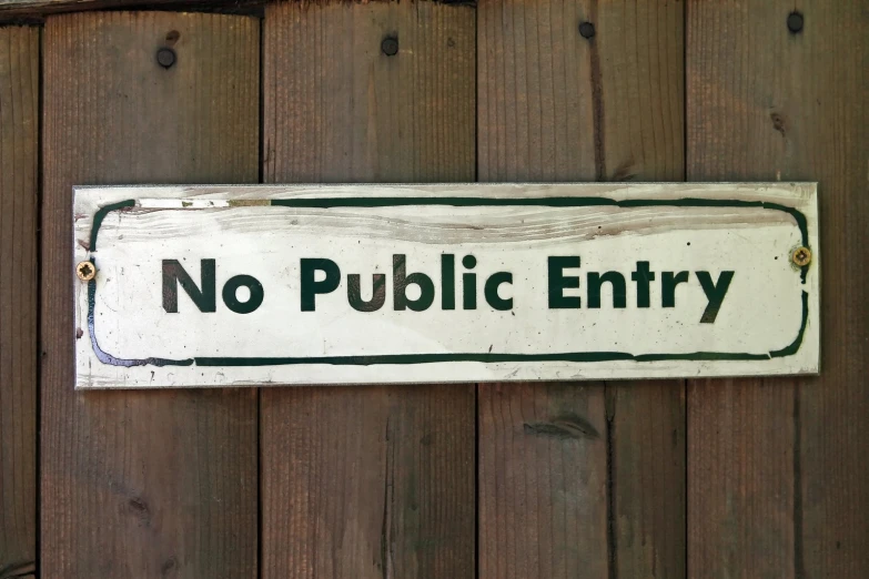 a sign reading no public entry hanging on a fence