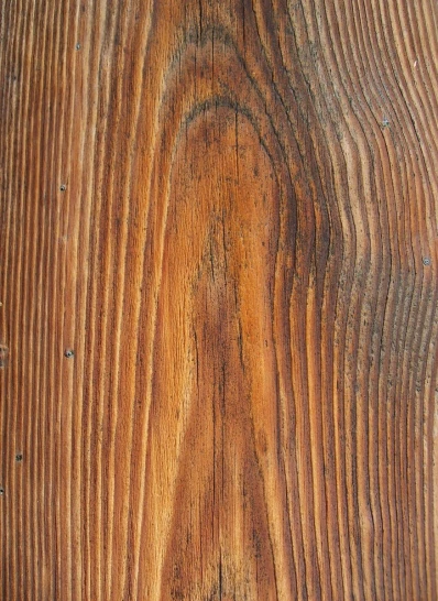 a brown wooden surface with ridges and scratches