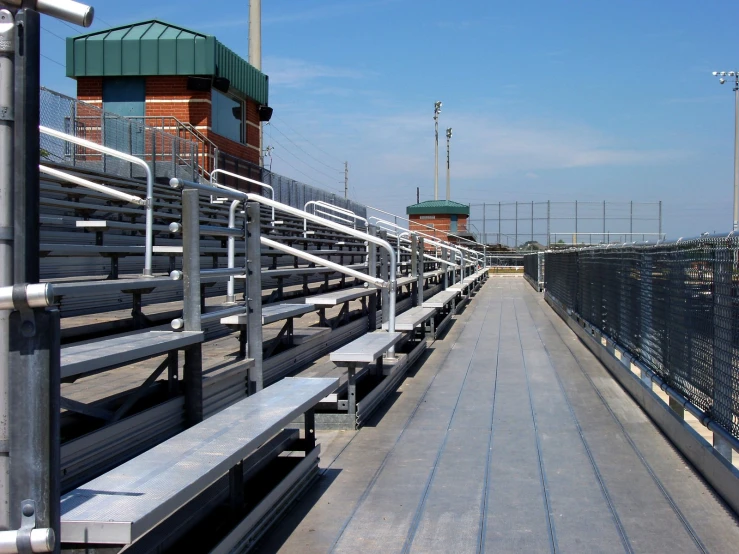 many seats sitting up against the edge of a long fence