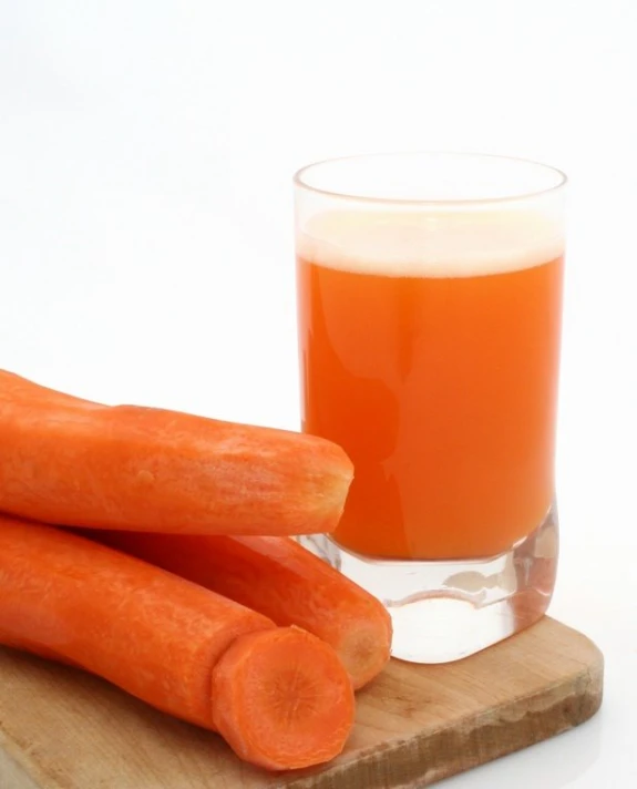 the carrots are next to the glass of beer