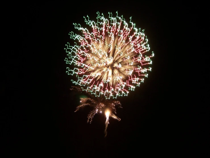 a large fireworks in the dark with a sky background