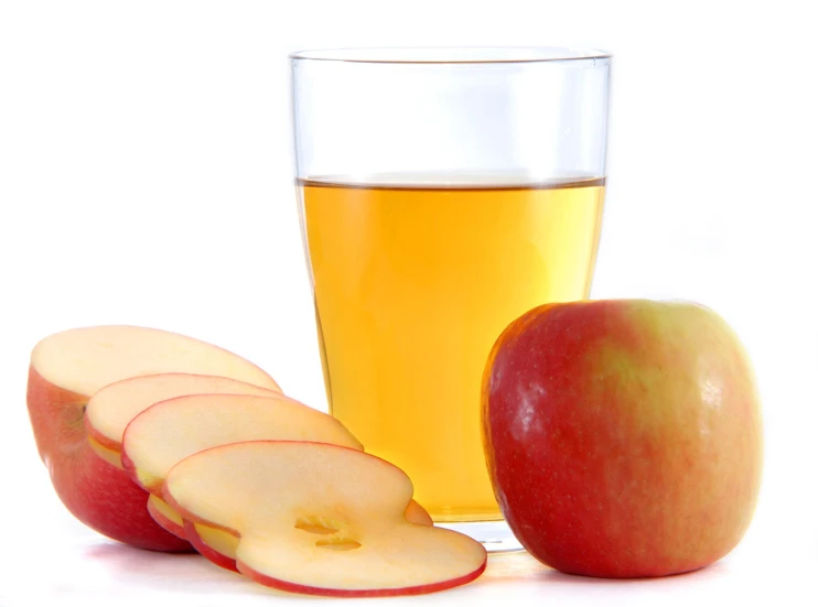 a cup of beer with several slices of apples and an apple slice with an apple wedge