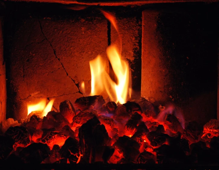 burning logs and rocks in a fireplace with red lights