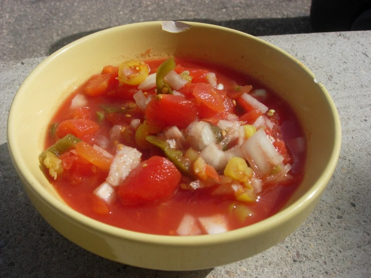 a bowl of tomato and onion soup with a spoon