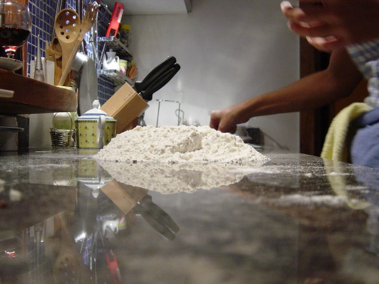 a cook preparing a pizza at a commercial kitchen counter