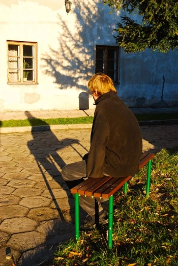 a young man sitting on top of a bench