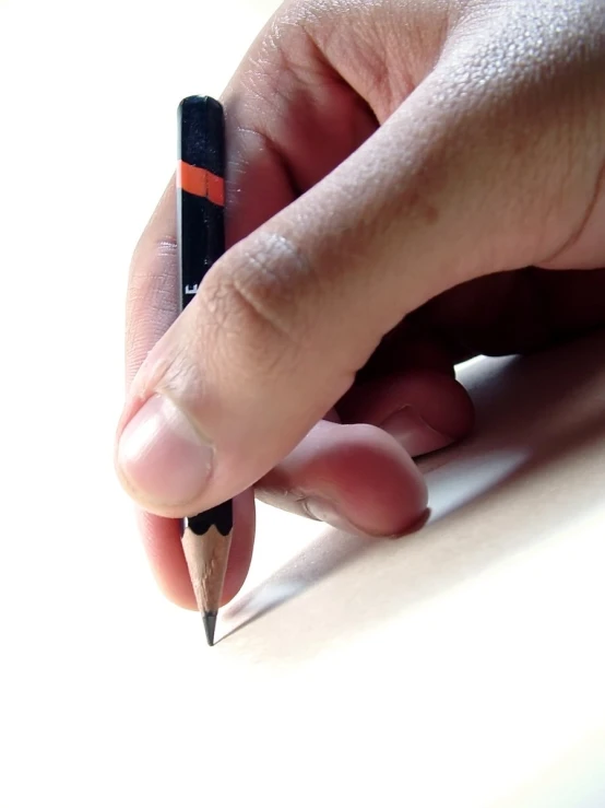 a person holding a pencil with their finger