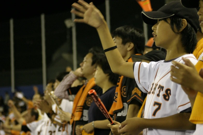 a crowd of people standing and clapping together