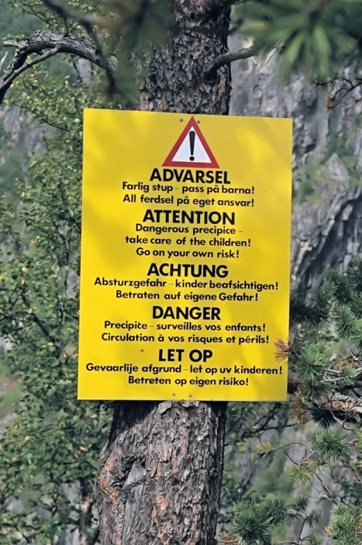 a sign on a tree warning about hiking