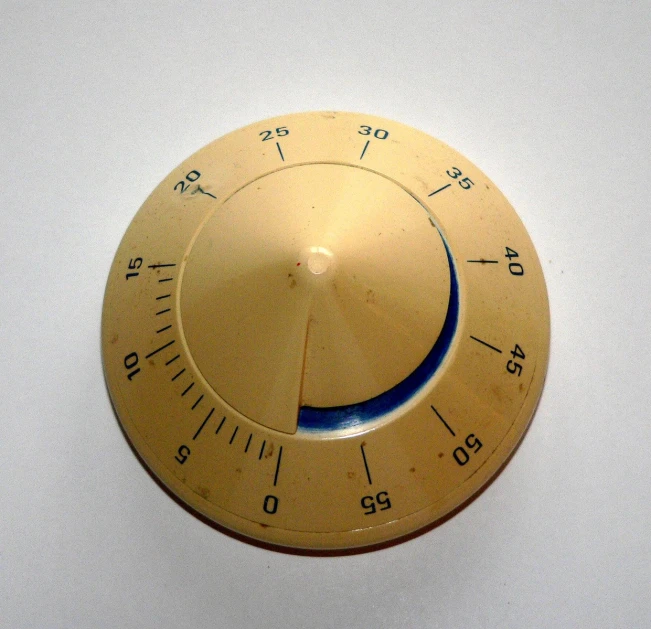 a gold timer is on the wall with a blue arrow