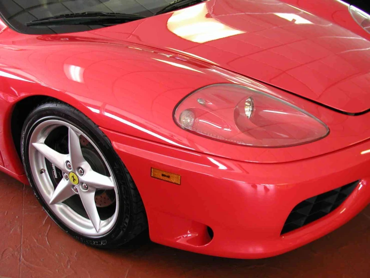 the front end of a red sports car in a warehouse