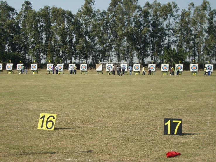 a group of people standing around a field with arrows pointing at numbered signs