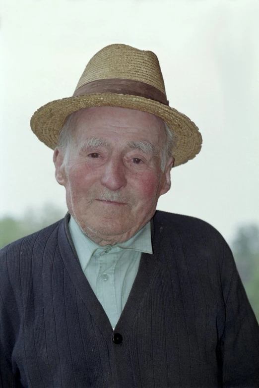 a man wearing a hat and a cardigan sweater