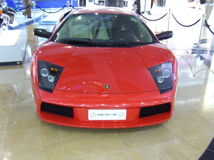 a red sports car is on display in a building