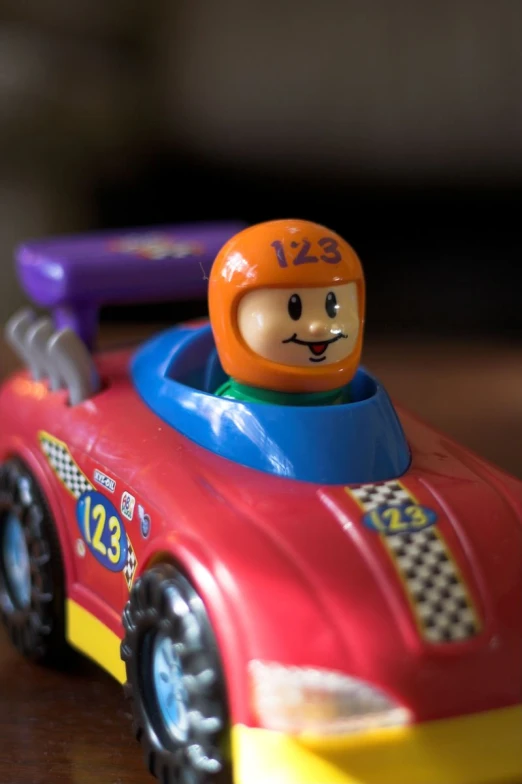 a little boy's toy car is displayed with a helmet on top