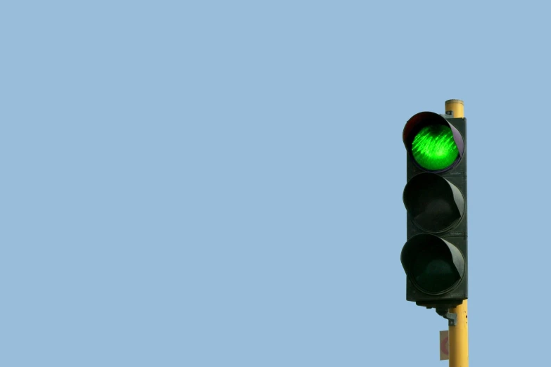 a traffic light with green light sitting on a pole